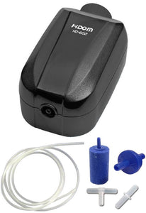 a single outlet aquarium air pump with a glossy black finish with a blue air stone, some transparent tubing plus valve and connectors